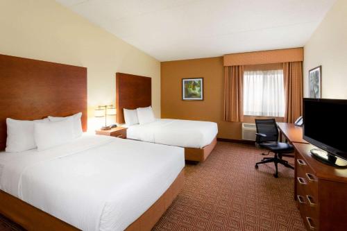 a hotel room with two beds and a flat screen tv at La Quinta Inn by Wyndham Minneapolis Airport Bloomington in Bloomington