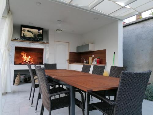 une salle à manger avec une table, des chaises et une cheminée dans l'établissement Apartments Roko, à Kaštela