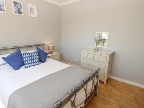 a bedroom with a large bed with blue pillows at Bankwell Cottage in Newcastle upon Tyne