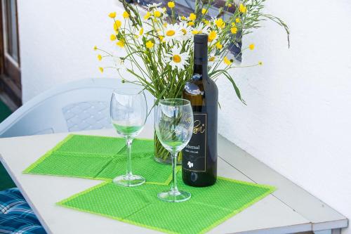 a bottle of wine and two glasses on a table at Areithof in Zell am See