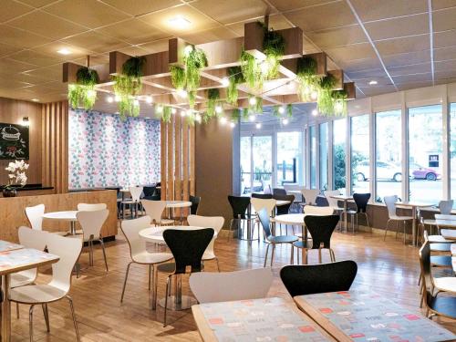 a restaurant with tables and chairs and windows at ibis Porto Alegre Moinhos de Vento in Porto Alegre