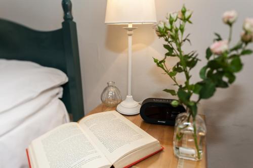 a bed with a book on it next to a lamp at Townhouse No 12 in Huddersfield