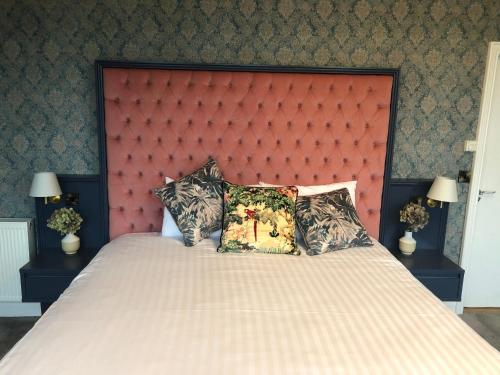 a bedroom with a large bed with a red headboard at Creighton Hotel in Clones