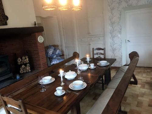 a wooden table with plates and candles on it at Au Plech in Mont-dʼAstarac