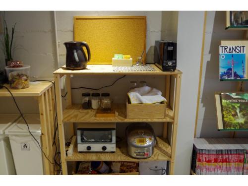 a shelf in a room with acomputer on it at Travelers' house ROOTs in Takaoka
