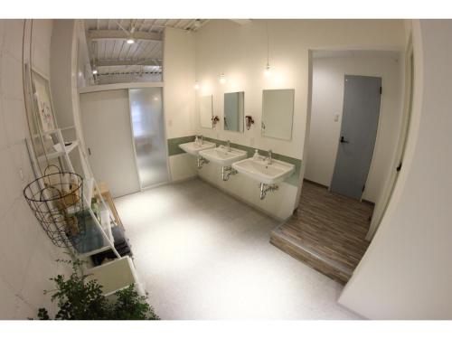 a bathroom with two sinks and two mirrors at Travelers' house ROOTs in Takaoka
