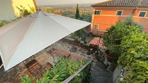a white umbrella sitting on top of a patio at La Magione dei Todaro in Borgo a Buggiano