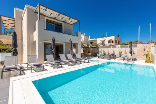 una piscina frente a una villa en Lagoon Seabreeze Villa, Sumptuous Retreat, By ThinkVilla, en Panormos Rethymno