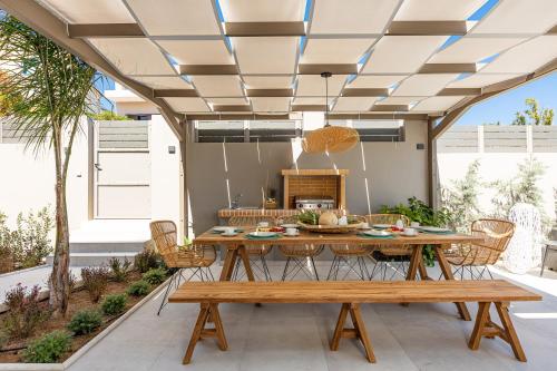 a patio with a wooden table and chairs at Lagoon Seabreeze Villa, Sumptuous Retreat, By ThinkVilla in Panormos Rethymno