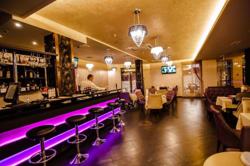 un bar con luces moradas en un restaurante en Denart Hotel en Sochi