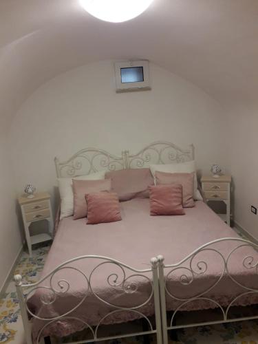 a bedroom with a bed with pink pillows at casa vacanze Vico Verona 7 in Oria