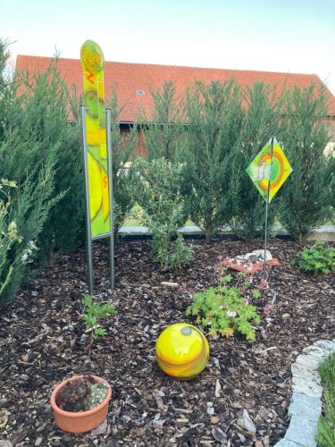 a garden with a yellow frisbee and a sign at Ferienwohnung St. Georg in Hemau