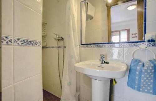 a bathroom with a sink and a mirror and a shower at La Casita in Grazalema