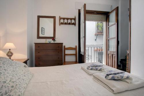 a bedroom with a bed and a dresser and a window at La Casita in Grazalema