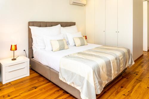 a bedroom with a large bed with a wooden floor at Fazenda Viegas in Lagos