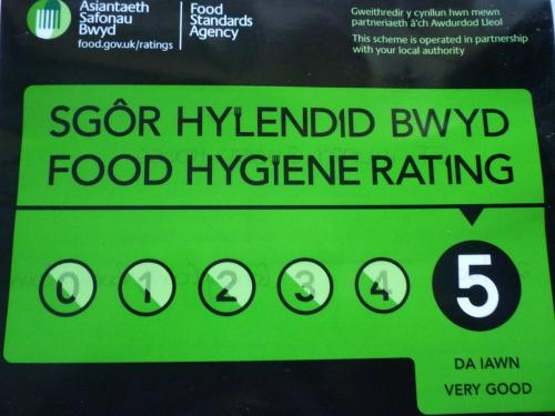 a green sign for a food hygiene rating at St. Hilary Guest House in Llandudno
