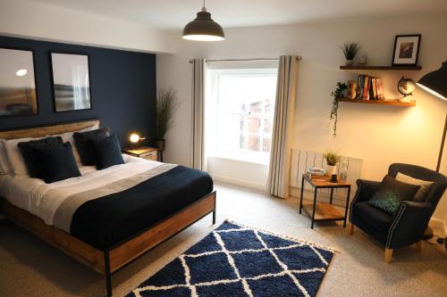 a bedroom with a bed and a chair and a window at Blueberry View-Wyndale-2BR Boutique Worcester in Worcester