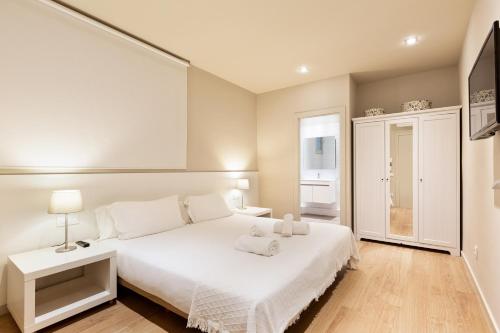 a hotel room with a bed and a dresser at Ola Living Hostal Diagonal in Barcelona