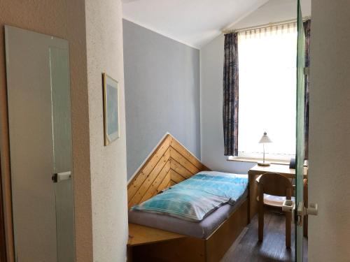 a small bedroom with a bed and a window at Hotel Göbel in Aachen