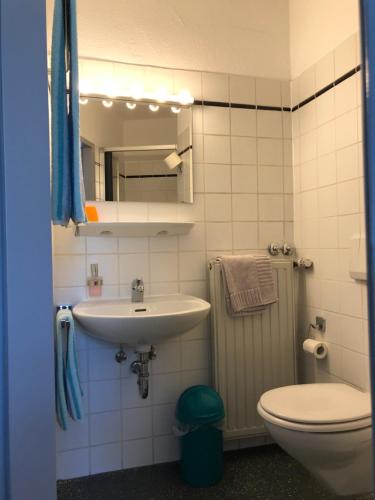 a bathroom with a sink and a toilet and a mirror at Hotel Göbel in Aachen