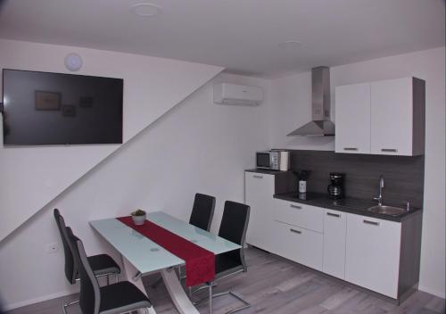 Apartmaji Anita في Begunje pri Cerknici: مطبخ مع طاولة وكراسي في غرفة