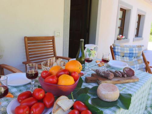 a table with a bowl of tomatoes and bread and wine at Farmhouse in Apecchio with Mountain Views in Apecchio