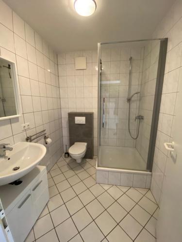 a bathroom with a shower and a toilet and a sink at Wohnung mit 2 Einzelzimmer gemeinsamer Küchen/Bad/Balkon-Nutzung in Espelkamp