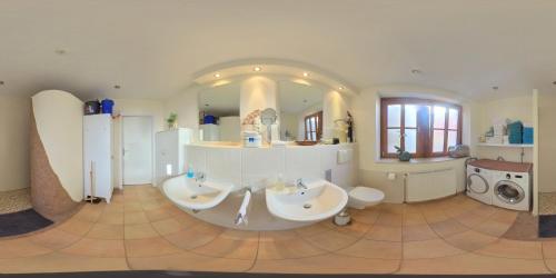 - une grande salle de bains avec deux lavabos et un grand miroir dans l'établissement Quartier am Schmiedefeuer, à Harsefeld
