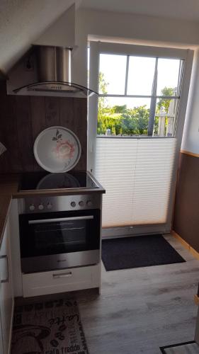 a kitchen with a stove and a window at Ferienwohnung Elbkoje in Brunsbüttel