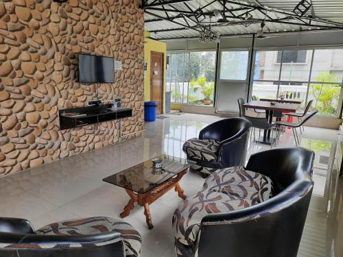 a lobby with chairs and tables and a stone wall at Bubble Beds in Kolkata