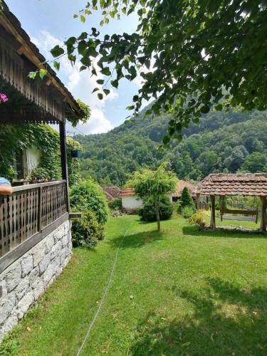un patio con una pared de piedra y un cenador en Плави вајат, en Gornje Leskovice