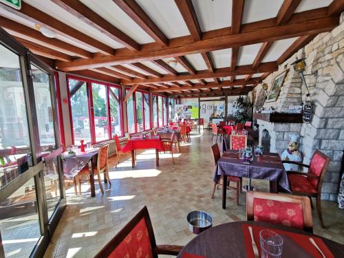 un restaurant avec des tables et des chaises et un mur en pierre dans l'établissement La Table Des Bons Peres, à Bislée