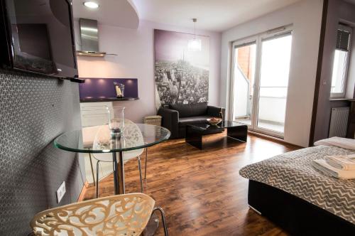 a living room with a glass table and a couch at Apartamenty AMB Bandurskiego in Szczecin