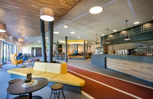 マリアツェルにあるJUFA Hotel Erlaufseeのソファとテーブルと椅子のあるロビー