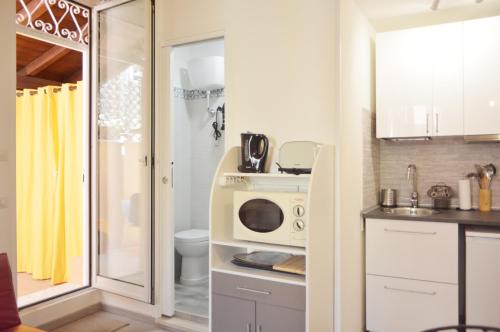 a small kitchen with a microwave and a sink at Bonaparte Suite Termini in Rome