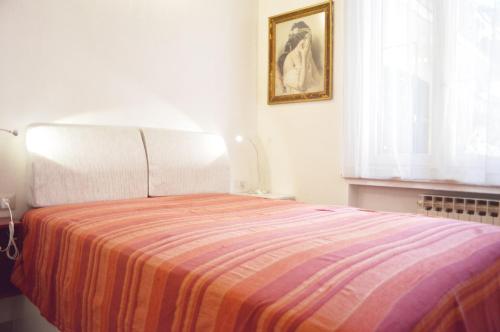 a bedroom with a bed with a striped blanket at Bonaparte Suite Termini in Rome