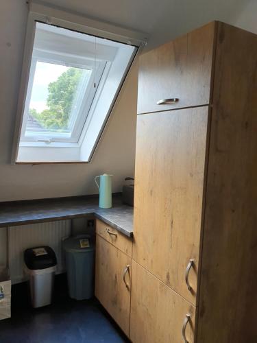 a kitchen with a skylight and a cabinet and a window at Nordsee-Koje in Brunsbüttel