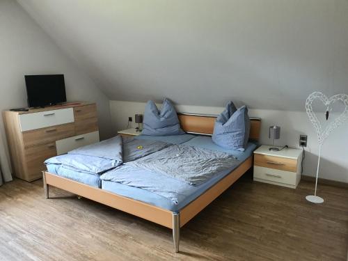 a bedroom with a bed with blue pillows on it at Nordsee-Koje in Brunsbüttel