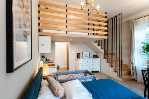 a living room with a blue couch and stairs at BOHO HOUSE in Ustrzyki Dolne