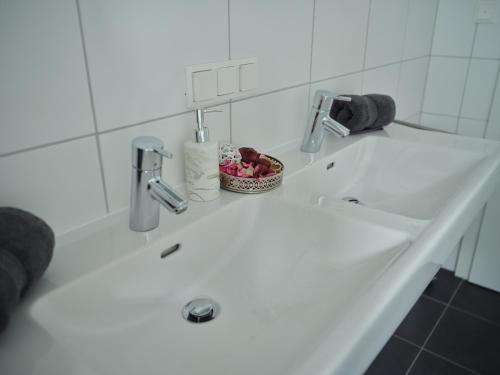 ein weißes Waschbecken mit einer Obstschale darauf in der Unterkunft Casa Alpina in Goldegg