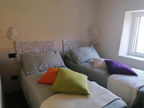 a room with two beds with colorful pillows on them at Casina Matilde in Varese Ligure
