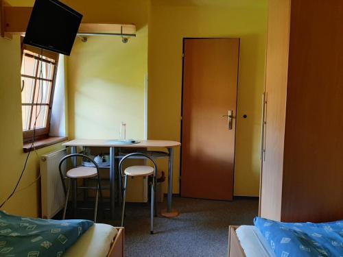 a room with a table and two chairs and a door at Pension Studenov in Rokytnice nad Jizerou