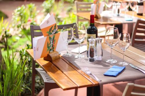 a table with glasses and a bottle of wine on it at Airport Hotel Casino du Cap-vert in Dakar