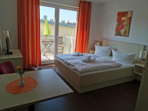 1 dormitorio con cama y vistas a un balcón en Ostseeapartment en Graal-Müritz