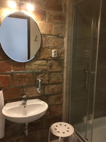 a bathroom with a sink and a mirror and a shower at Jókai Vendégház Homokkomárom in Homokkomárom