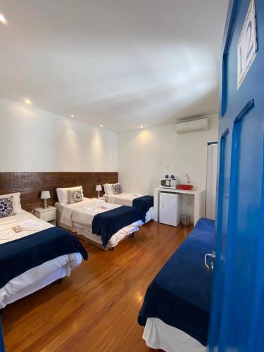 a hotel room with two beds and a desk at Pousada e Hostel São Paulo Comfort - Bairro Pinheiros, próximo Hospital das Clínicas e Incor, Oscar Freire, Av Paulista, Allianz, Vila Madalena e fácil acesso ao Ibirapuera e Morumbi in Sao Paulo