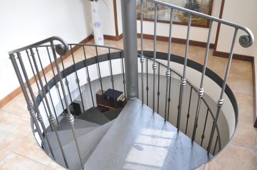 a spiral staircase with a metal railing at B&B Sanpancrazio in Vale