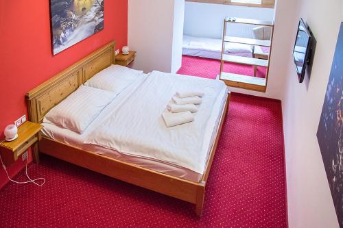 a bedroom with a bed with two towels on it at Horský hotel Vidly in Karlova Studánka