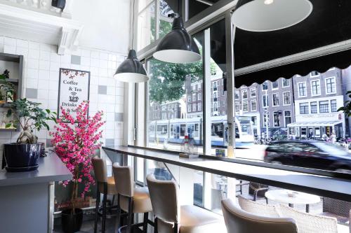 a bar in a restaurant with a view of a street at Hotel Jesse in Amsterdam