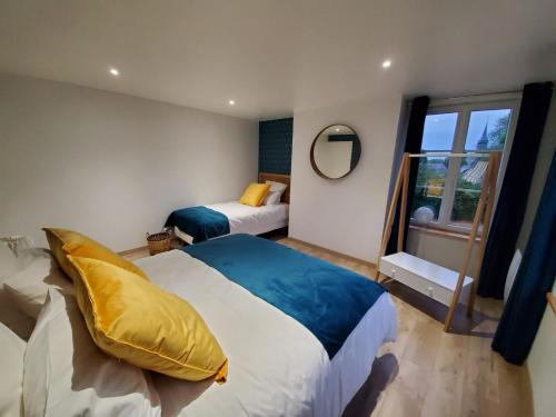 a bedroom with two beds and a window at La Maison des Jonquerets in Jonquerets-de-Livet